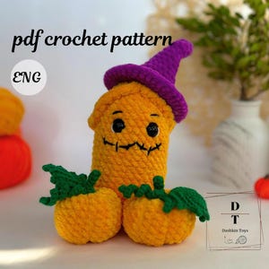 May include: Crochet pattern for a Halloween pumpkin with a purple hat and a stitched-on face. The pumpkin is holding two smaller pumpkins. The pattern is available in English.  The text "pdf crochet pattern" and "ENG" are visible in the image.