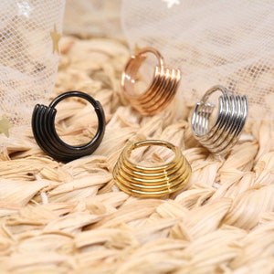 Op de afbeelding: Vier verschillende stijlen van creolen met meerdere ringen. De oorbellen zijn gemaakt van metaal en zijn verkrijgbaar in zwart, goud, zilver en rosé goud.