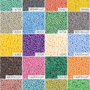 May include: Assortment of 16 different colors of seed beads, each color displayed in a square. The beads are small and round, and they are arranged in a grid pattern. The colors include green, gray, orange, yellow, silver, blue, purple, white, brown, pink, teal, gold, and peach.