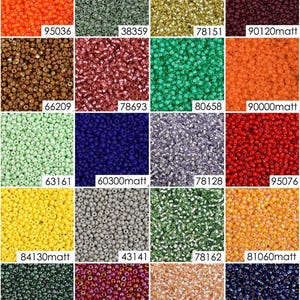May include: Assortment of 16 small glass seed beads in various colors, including orange, green, gold, brown, red, blue, silver, and yellow. The beads are arranged in a grid pattern.
