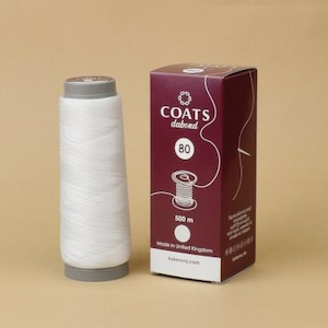 May include: A white spool of thread next to a maroon box. The box has the text "COATS dabond 80" and an illustration of a thread spool. The box also states "500 m" and "Made in United Kingdom".