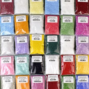 May include: Assortment of 24 small bags of seed beads, each bag containing a different color of beads. The bags are labeled with the brand name "Preciosa Ornela" and a number. The beads are all size 10/0.