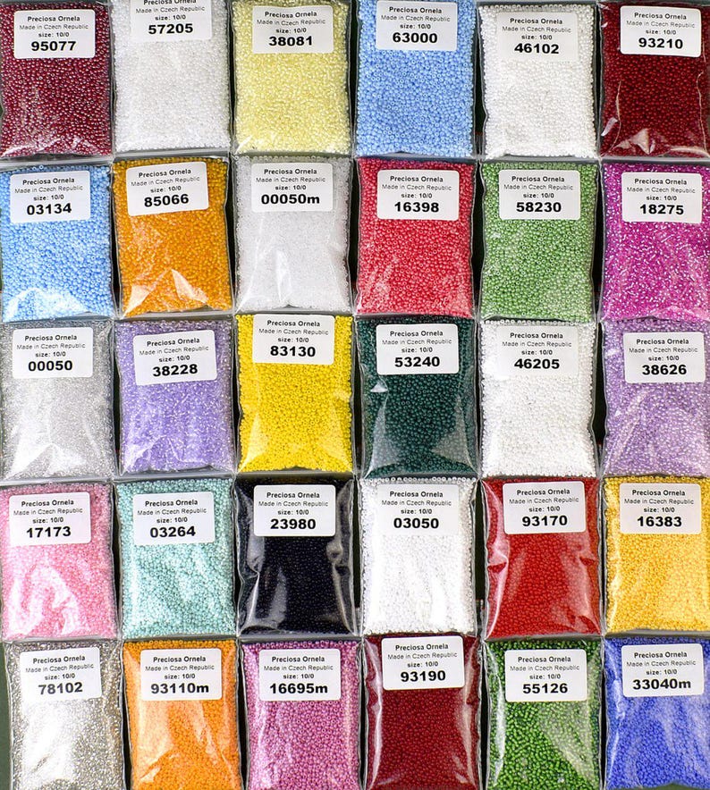 May include: Assortment of 24 small bags of seed beads, each bag containing a different color of beads. The bags are labeled with the brand name "Preciosa Ornela" and a number. The beads are all size 10/0.