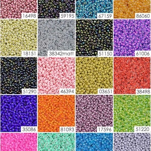 May include: Assortment of seed beads in various colors, including pink, blue, green, orange, and purple. The beads are arranged in a grid pattern.