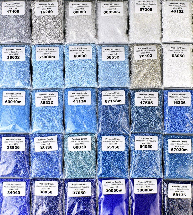 May include: Assortment of small, round, glass beads in various shades of blue, white, and gray. The beads are packaged in clear plastic bags with labels indicating the size and manufacturer, Preciosa Ornela, Made in Czech Republic.