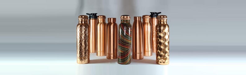 K&ouml;nnte beinhalten: Eine Sammlung von Kupfer-Wasserflaschen mit verschiedenen Designs und Oberfl&auml;chen. Die Flaschen sind alle gleich gro&szlig; und haben die gleiche Form, aber unterschiedliche Muster und Texturen. Einige der Flaschen haben eine glatte Oberfl&auml;che, w&auml;hrend andere eine geh&auml;mmerte oder strukturierte Oberfl&auml;che haben. Die Flaschen sind alle aus Kupfer gefertigt und haben eine gl&auml;nzende Oberfl&auml;che.