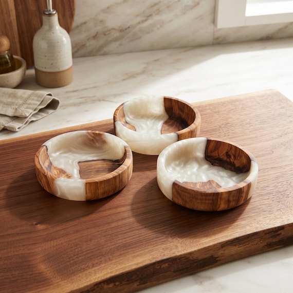 The swirling contrast of dark epoxy resin rivers through warm olive wood grain makes this tiny bowl a miniature piece of visual art.