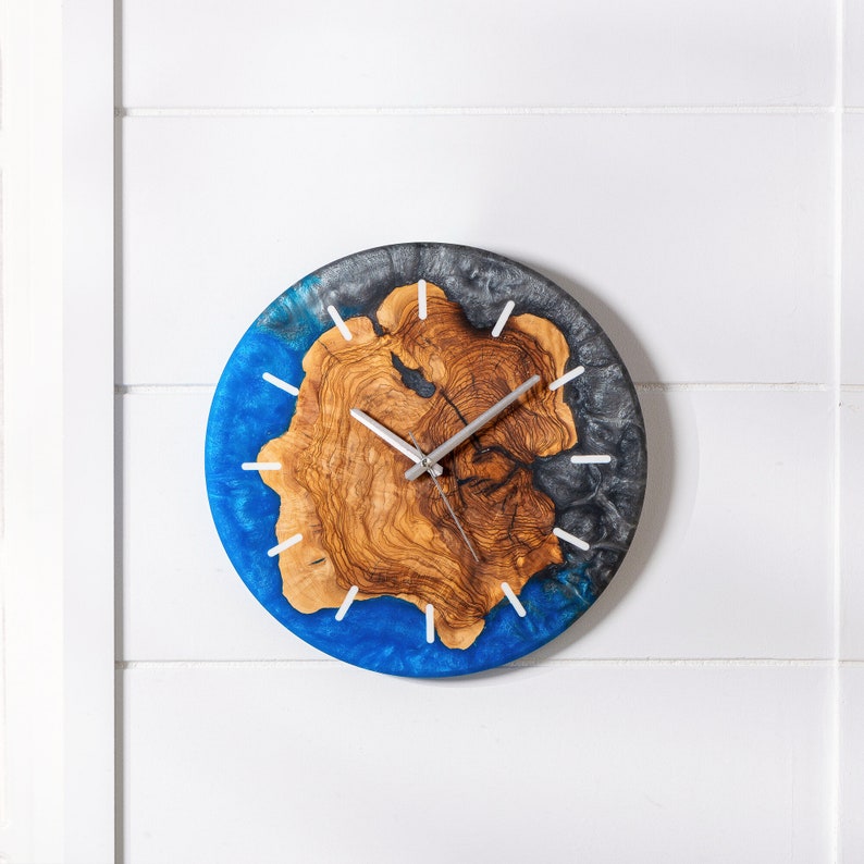 May include: A blue and gray resin clock with a wood grain design. The clock has silver hands and white markings.