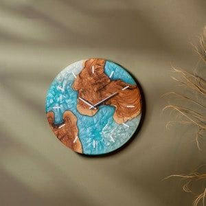 May include: A round wall clock with a blue and brown resin design. The clock face has silver hands and white markings.