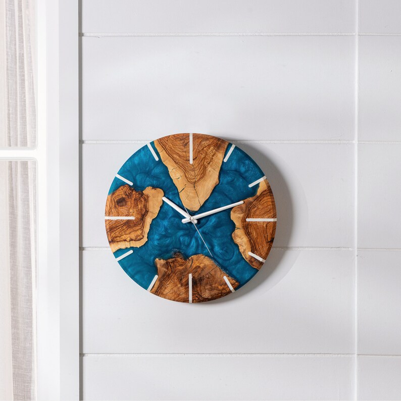 May include: A blue and brown resin clock with white hands. The clock is mounted on a white wall.