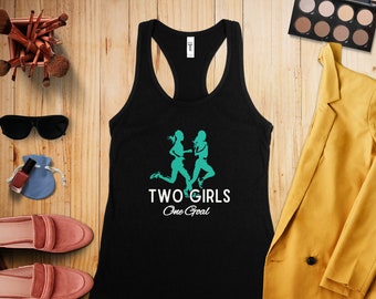 May include: Black tank top with a teal silhouette of two women running and the text "TWO GIRLS One Goal".