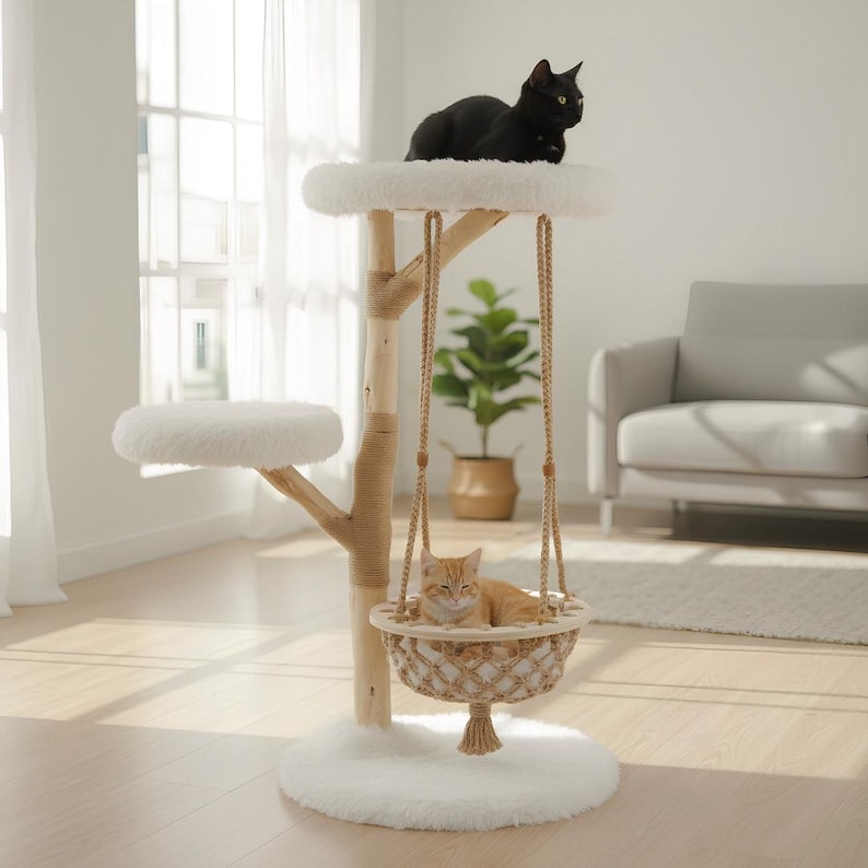 May include: A multi-level cat tree with a black cat on top and an orange cat in a hanging basket. The tree has a natural wood finish with rope accents, white plush platforms, and a fluffy base. The cat tree is designed for indoor use.