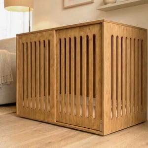 May include: A rectangular wooden pet crate featuring a light brown finish and vertical slats along the front and side panels. The structure includes a sliding door mechanism with a visible metal latch, providing an enclosed space for pets.