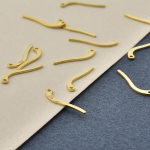 Puede incluir: Una colección de componentes de joyería de metal dorado curvados, cada uno con un pequeño lazo circular en un extremo. Varias de estas piezas están estampadas con el texto 925, lo que indica una base de plata esterlina, esparcidas.