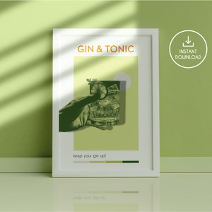 A green color Gin Tonic downloadable poster, carrying a vintage vibe, with an image of a hand holding a cocktail glass, stands leaning against the compatible color Wall in a room with smooth flat ground.