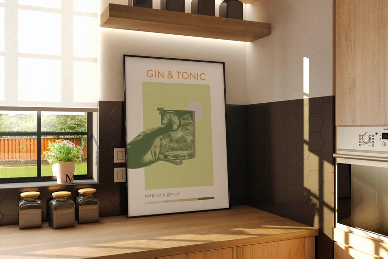 The green color Gin Tonic print, retro vibe effects, a hand holding a cocktail glass, leaning against the wall on the counter in front of the kitchen window of a modern minimalist house. There are tiny flowers and jars of coffee on the side.