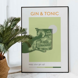 A Gin Tonic cocktail poster with a green color, also carrying retro vibe effects, a hand holding a cocktail glass, is leaning against the wall in a room with a white marble floor and white walls, and a potted plant stands next to it.