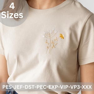 May include: A beige t-shirt with an embroidered floral design. The design features white and yellow flowers with gold stems. The text "4 Sizes" is in a white circle at the top. The bottom of the shirt has the text "PES-JEF-DST-PEC-EXP-VIP-VP3-XXX".