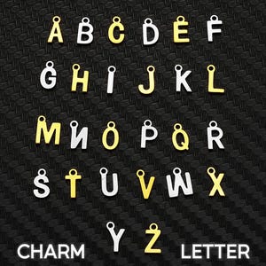 May include: A collection of alphabet letter charms arranged in rows. Each letter features a small circular loop at the top for attachment. The charms alternate between a metallic gold finish and a silver finish, displaying the full alphabet from A to Z.