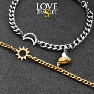 May include: Two bracelets with chain links. One is silver with a crescent moon charm, and the other is gold with a sun charm. A gold and silver heart charm hangs from the silver bracelet. The text "LOVE BRASLET" is in the upper center.