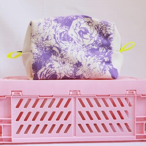 Trousse de maquillage floral lilas, cousue main et sérigraphiée à Londres. Doublure en velours rose pelucheux et pattes de ruban gros-grain jaune fluo.