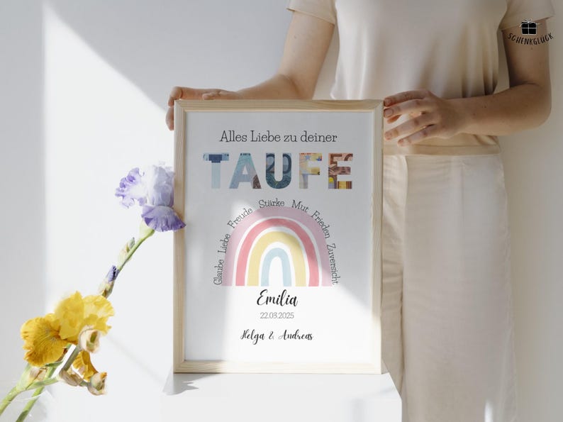 Personalisierbares Geldgeschenk Taufe Mädchen mit Geld in einem hellen Holzbilderrahmen steht auf einem weißen Tisch und wird von einer Frau in heller Kleidung gehalten. An dem Bilderrahmen lehnt eine gelb-lila Blume.
