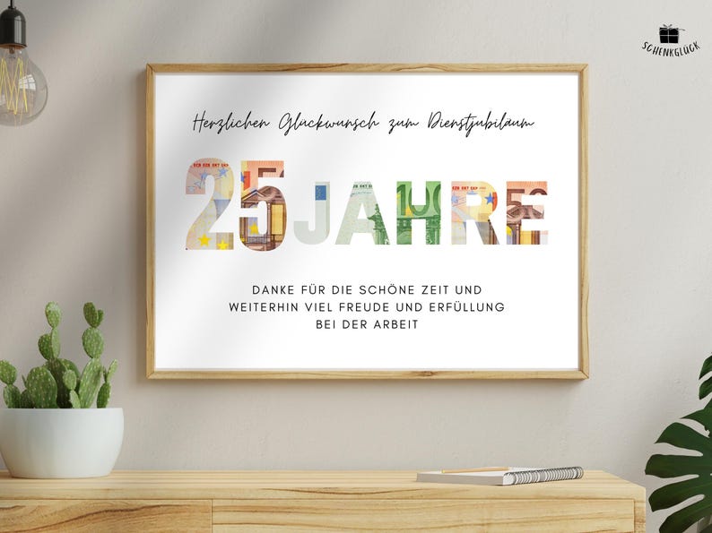 Geschenk Dienstjubilaeum 25 Jahre in Holzbilderrahmen über einem Holzregal mit einem Kaktus und einem Notizbuch darauf