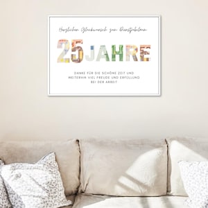 Geschenk zum Dienstjubilaeum in einem weißen Bilderrahmen an einer Wand ueber einem Sofa mit Kissen darauf