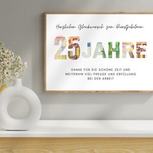 Geschenk Dienstjubilaeum 25 Jahre in einem Holzbilderrahmen ueber einem Regal mit einer Vase und einer Blume darauf