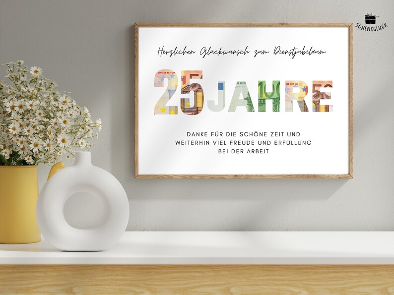 Geschenk Dienstjubilaeum 25 Jahre in einem Holzbilderrahmen ueber einem Regal mit einer Vase und einer Blume darauf
