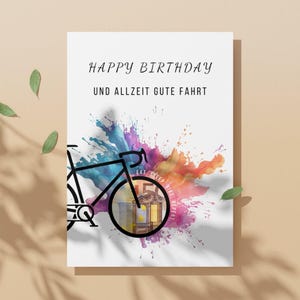 Geldgeschenk Fahrrad Geburtstag vor einem orangenen Hintergrund mit grünen Blättern