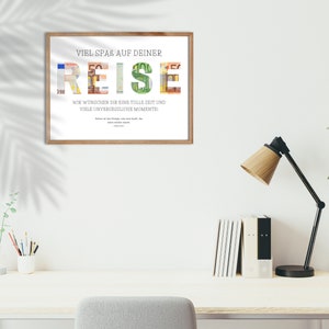 Geldgeschenk Reisekasse in einem Holzbilderrahmen hängt an einer weißen Wand über einem Schreibtisch. Auf dem Schreibtisch stehen eine Pflanze, Stif, Bücher sowie eine Lampe. Daneben steht eine Pflanze und davor ein Schreibtischstuhl.