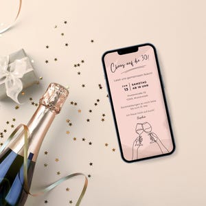 Ein Smartphone, auf welchem die digitale Einladung zum Geburtstag abgebildet ist, liegt auf einem Tisch mit einer beigen Tischdecke. Daneben sind ein kleines Geschenk, eine Sektflasche sowie Konfetti und Luftschlangen zu sehen.