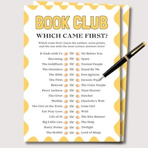May include: A yellow and white Book Club game card with the text "BOOK CLUB WHICH CAME FIRST?" and a list of book titles. A black and gold pen rests on the card. The game card is designed to be a fun activity.