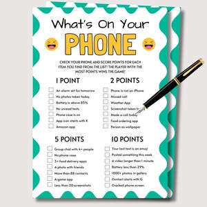 May include: A teal and white game card titled "What's On Your Phone" with a list of tasks to score points. A black and gold pen rests on the card. The game card has a teal border with white wavy lines and green accents.
