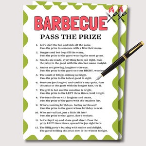 May include: A barbecue party game card with the title "BARBECUE PASS THE PRIZE" in red letters. The card has a green and white border and includes instructions for the game. A black and gold pen is resting on the card.
