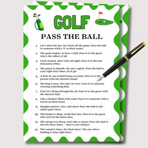 May include: A white card with a green border and golf-themed graphics. The card features the word "GOLF" in large green letters and the phrase "PASS THE BALL." A black pen with gold accents rests on the card. The card contains a list of instructions for a golf-themed game.