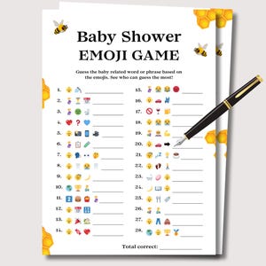 May include: A white paper game sheet titled Baby Shower EMOJI GAME with bee and honeycomb graphics. The sheet features twenty-eight numbered lines with emoji sequences for guessing baby-related words, and a black fountain pen rests on top.