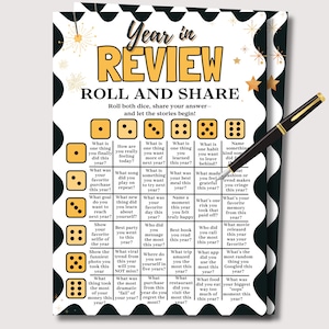 May include: A black and white Year in Review poster with gold text and dice prompts. Includes a black pen with gold accents. The poster encourages sharing stories and rolling dice to answer questions about the year.