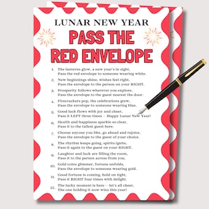 May include: A Lunar New Year greeting card with red and white wavy borders and the text "Pass the Red Envelope." A black and gold pen rests on the card. The card lists instructions for the game.
