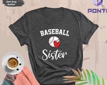 May include: Dark gray heather t-shirt with a white baseball and red heart graphic. The text "Baseball Sister" is printed on the shirt.