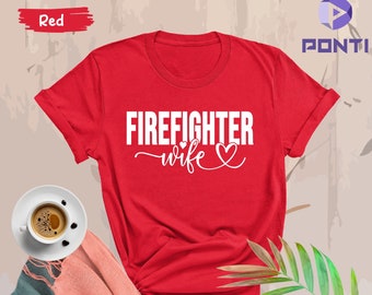 May include: Red t-shirt with white text that says "Firefighter wife" with a heart symbol.