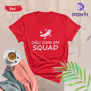 May include: Red t-shirt with a white chili pepper graphic and the text "Chili Cook Off Squad".