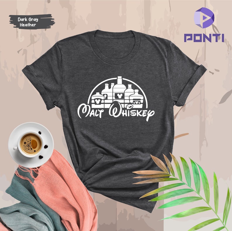 Op de afbeelding: Donkergrijs heather t-shirt met een witte afbeelding van een Mickey Mouse-hoofd met een kasteel silhouet en de tekst "Malt Whiskey".