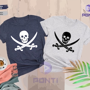 May include: Two t-shirts, one navy blue and one heather gray, each featuring a white or black skull and crossbones design. The shirts are short-sleeved and have a crew neck.