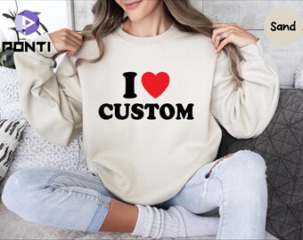 May include: A cream colored sweatshirt with a black graphic that says "I love custom" with a red heart.