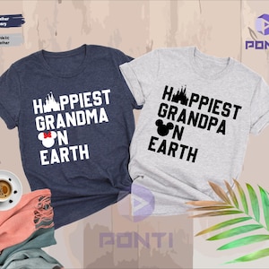 Könnte beinhalten: Zwei kurzärmelige T-Shirts, eines in Marineblau und eines in Heather Grey, mit den Texten "Happiest Grandma on Earth" und "Happiest Grandpa on Earth" in Weiß. Die Designs beinhalten ein Schloss und einen Mickey Mouse-Kopf.