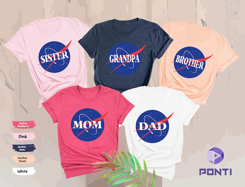 K&ouml;nnte beinhalten: F&uuml;nf T-Shirts mit einem Weltraum-Design. Die Shirts sind in Pink, Marineblau, Pfirsich, Rot und Wei&szlig;. Die Shirts haben die Worte "Schwester", "Opa", "Bruder", "Mama" und "Papa" darauf.