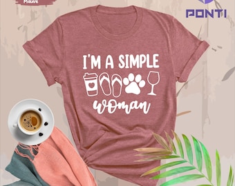 May include: A heather mauve t-shirt with the text "I'm a simple woman" in white. The text is surrounded by icons of a coffee cup, flip flops, a paw print, and a wine glass.