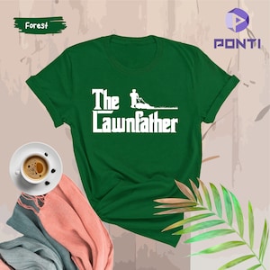 May include: A green t-shirt with the text "The Lawnfather" in white. A white silhouette of a person mowing a lawn is above the text.